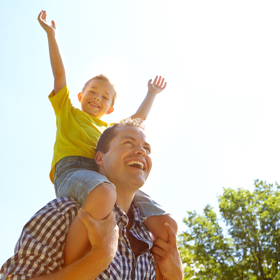 Upper Cervical Spine Care, a proactive approach for stress and anxiety. Smiling father carrying his joyful son on his shoulders, enjoying pain-free movement and quality time together thanks to upper cervical care for back and neck pain relief.