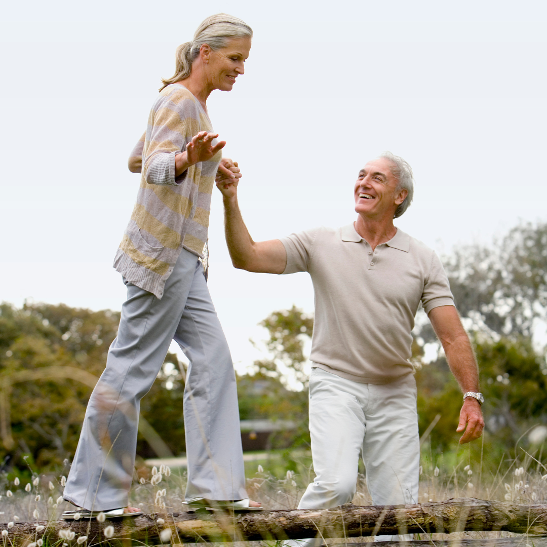 Happy senior couple enjoying the outdoors with ease and balance, thanks to upper cervical care that helped relieve back pain and vertigo.